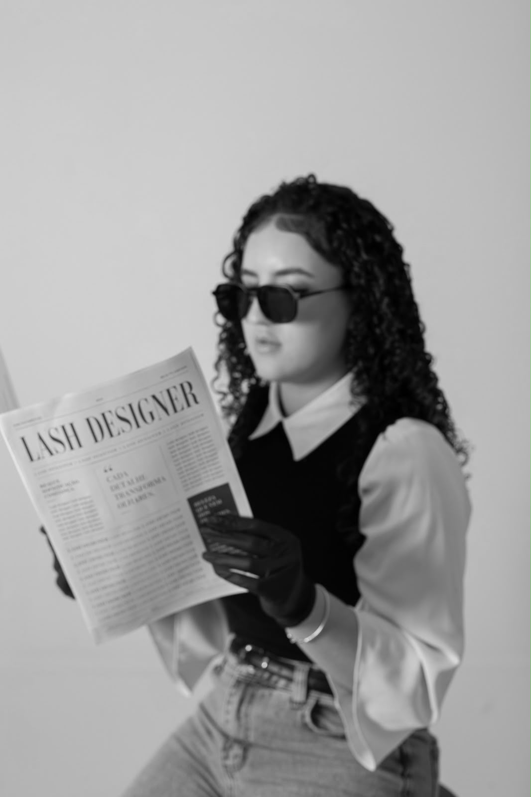 Retrato corporativo em preto e branco com óculos escuros e jornal